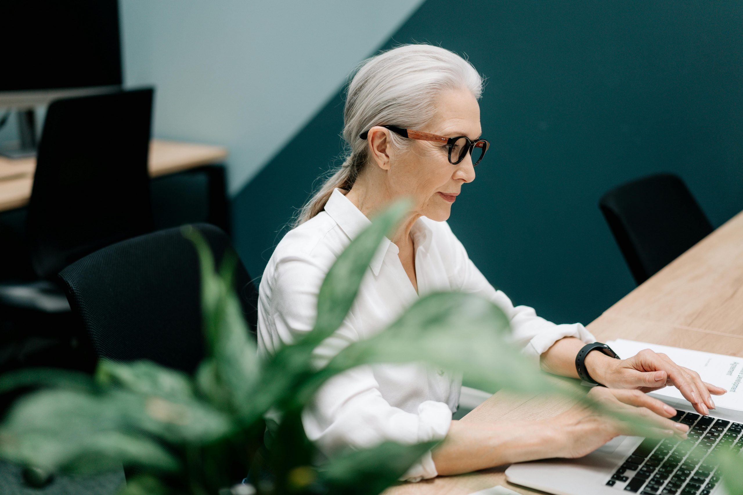 woman wearing eyeglasses working on a laptop